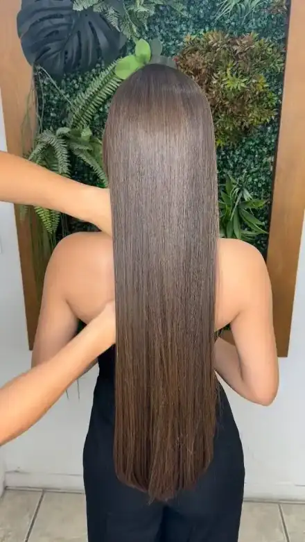 Cabelo liso de costas entre folhagens