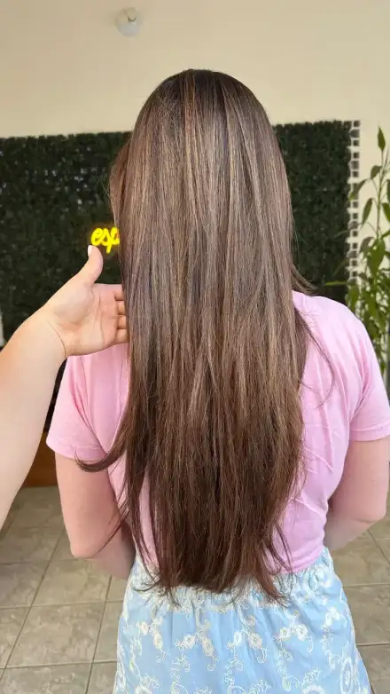 Cabelo liso e longo de costas, com uma flor amarela