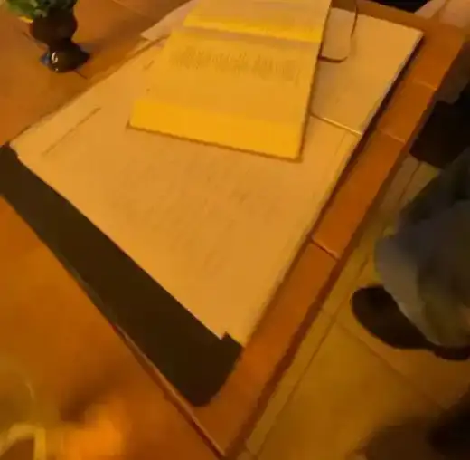 Mesa com papéis e uma planta durante um encontro à noite no salão